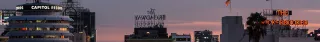 The Los Angeles skyscrapers at dawn with "The Broadway Hollywood" sign facing away from the camera